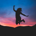 woman jumping at sunset