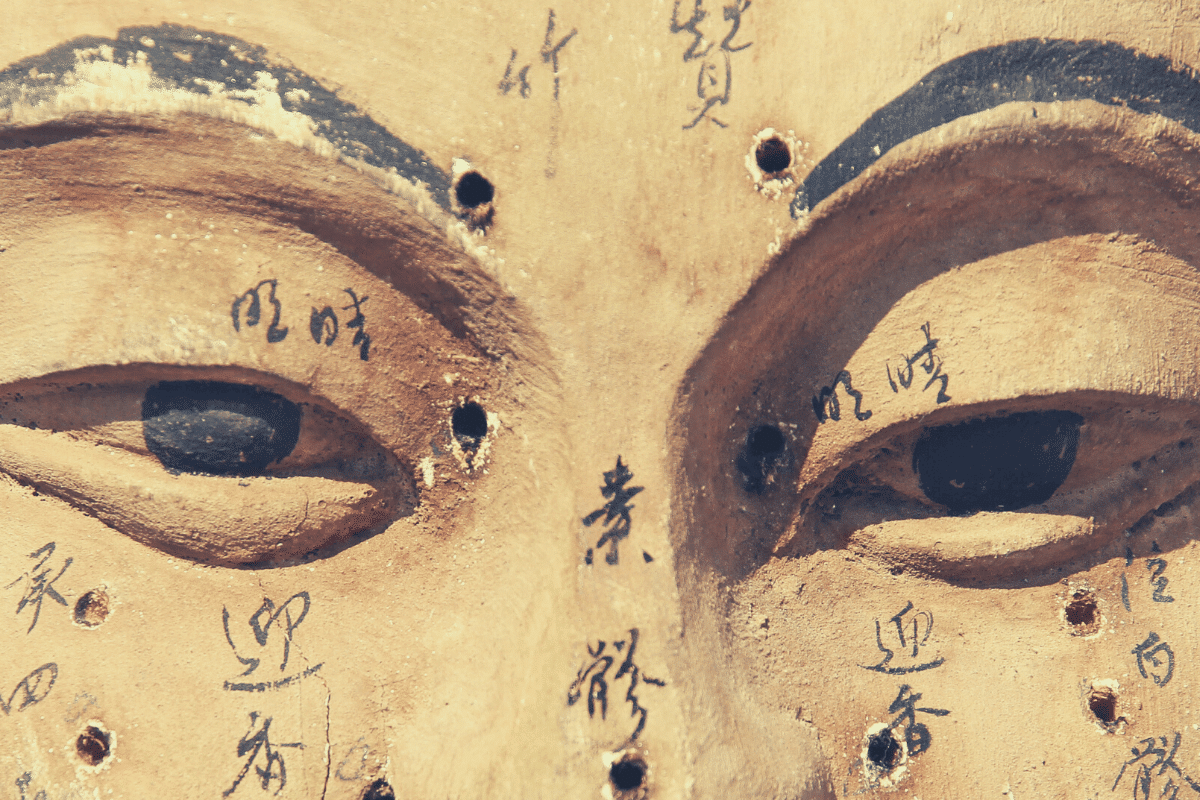 Sculpture of face marked with paint on traditional Chinese medicine meridians and acupressure points