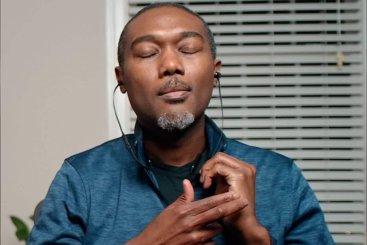 Man with eyes closed and headphones on doing EFT Tapping meditation